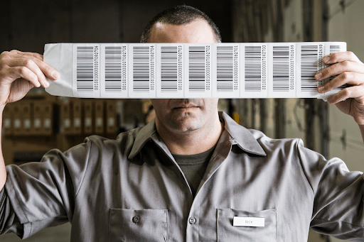 A man holding a roll of barcodes over his eyes