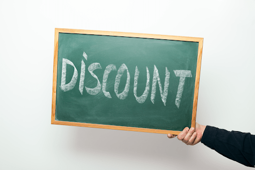 A chalkboard being held with the word discount on it